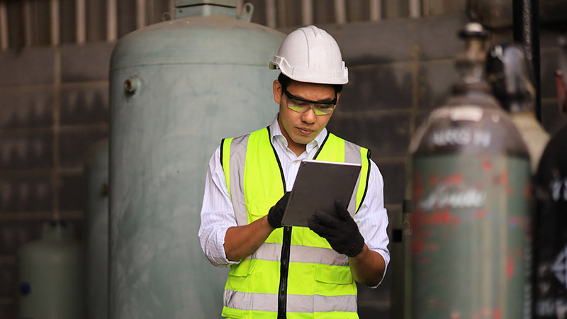 An industrial worker looking at a tablet.