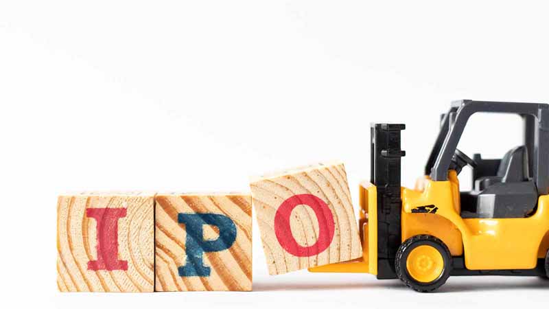 Toy construction vehicle moving blocks to spell "IPO."