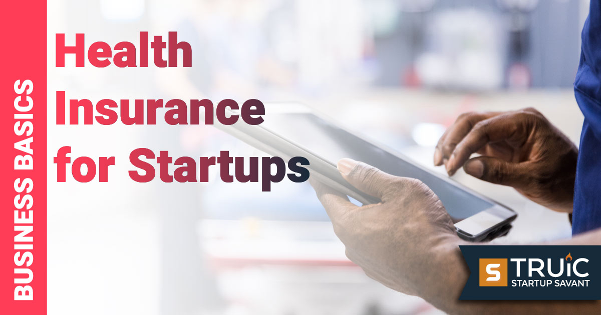 Man looking at health insurance for startups on a tablet.