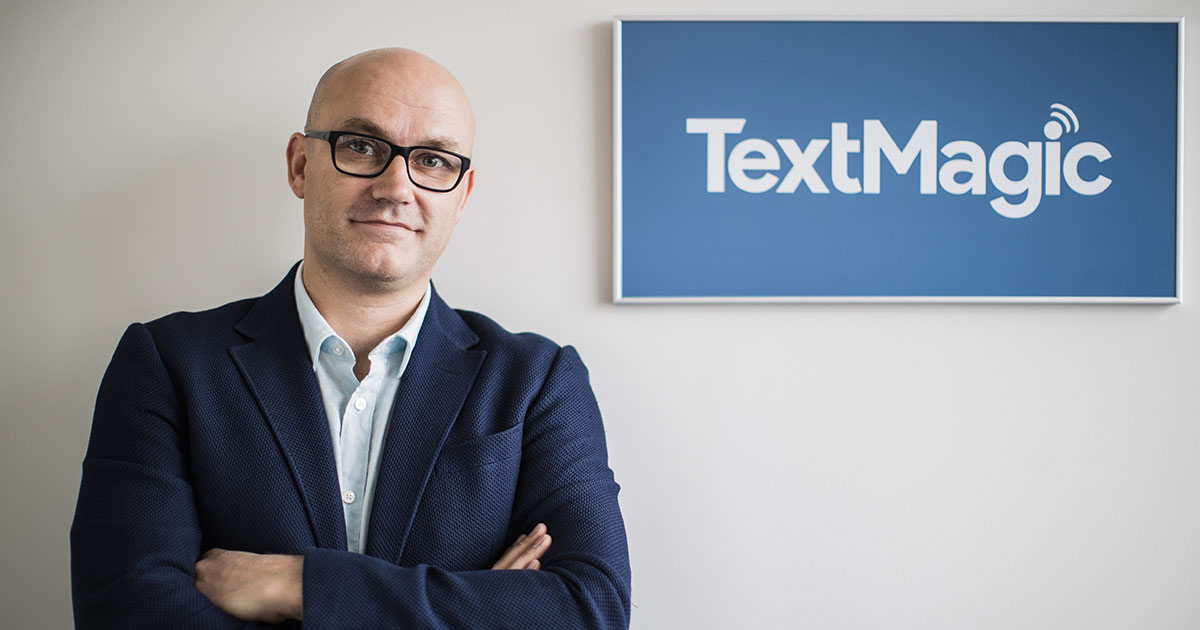 TextMagic founder with logo.