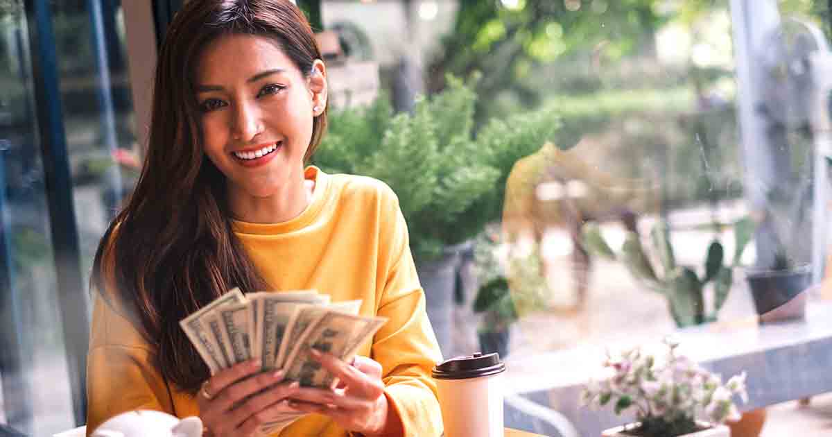 Smiling woman holding money.