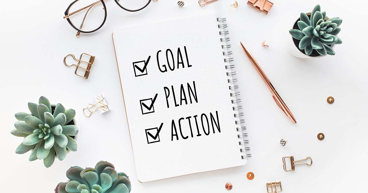 Notepad stating, "Goal, Plan, Action" and various office accessories.