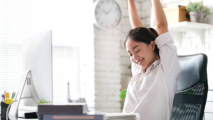 Woman stretching at her desk.