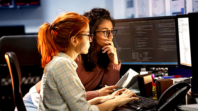 Two female coworkers coding.